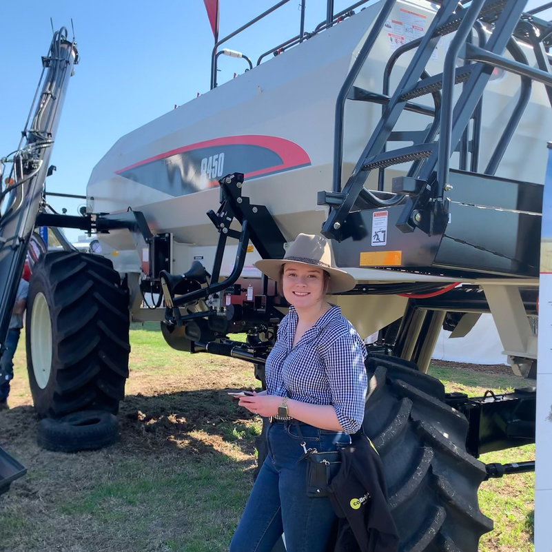 Caitlin poses in front of a Bourgault 8450 Air Cart