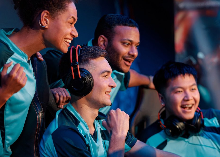 4 gamers celebrating together at a computer setup