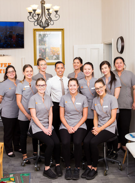 Westside Orthodontics team in their waiting room. The space is well decorated with frames artwork and a small chandelier