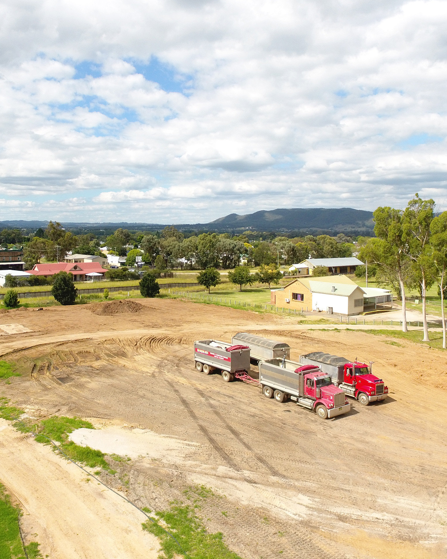 Two trucks parked on an earthworks moving site