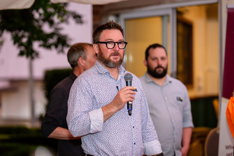 Brendan talking into a microphone at the CoBright Soiree