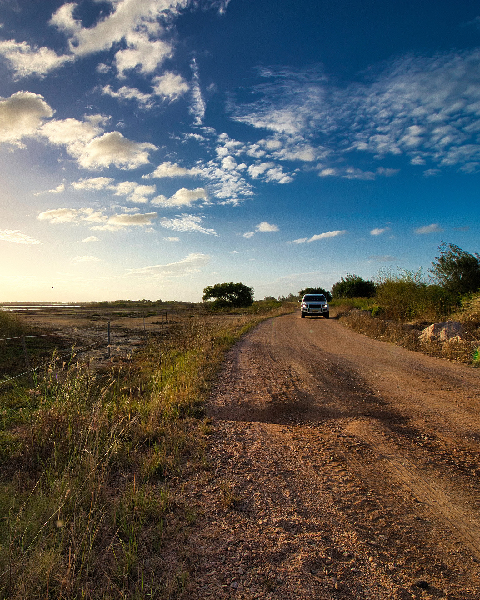 A car driving down a dirt road in rural Australia